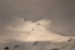 Creuament de muntanyes entre núvols al capvespre